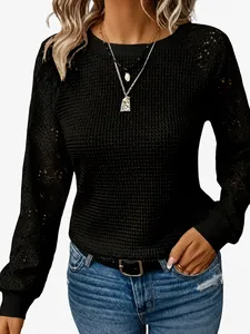 Detailed texture of women's black hollow-out lace long sleeve casual top with round neck