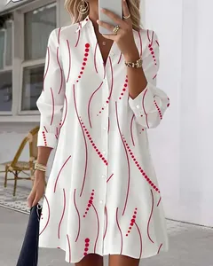Detailed view of an elegant white shirt dress featuring a vibrant red wavy dot pattern
