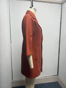 Vue latérale d'un manteau en laine orange avec col à revers et manches 3/4 sur mannequin.