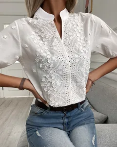 Detail view of white stand collar blouse with intricate floral embroidery and V-neckline