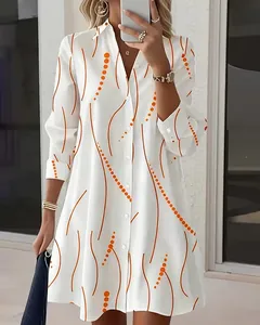 Detailed view of elegant white shirt dress with orange wave and polka dot print pattern