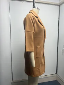 Vue de côté d'un manteau en laine camel avec manches 3/4 sur un mannequin de couture