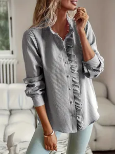 Elegante camisa a rayas con delicados detalles de volantes y cierre frontal de botones