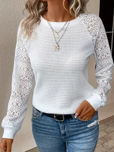 Elegante witte kanten top met opengewerkte details, lange mouwen en ronde hals dames.