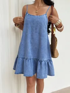 Detail view of a summer denim mini dress with ruffled hem and spaghetti straps