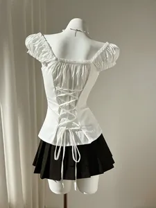 Detailed back view of white puff sleeve shirt featuring adjustable lace-up corset design.