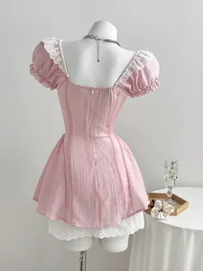 Detailed back view of a pink puff sleeve mini dress with delicate white lace trim.