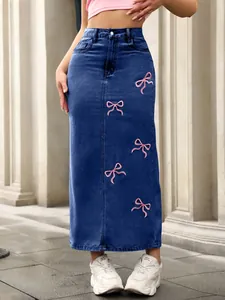 Detailed view of high-waisted denim midi skirt with pink embroidered bow accents