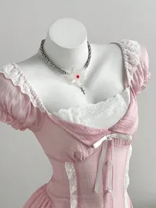 Detailed view of the delicate white lace trim and bow on this pink puff sleeve mini dress.