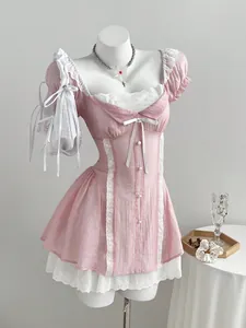 Detailed shot of a pink puff sleeve mini dress featuring white lace trim and cute bows