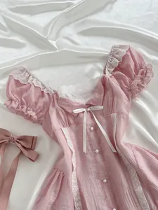 Close-up detail of a pink mini dress featuring puff sleeves and white lace accents
