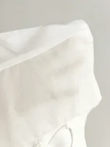 Detailed macro view showing the texture of lightweight white fabric on women's blouse
