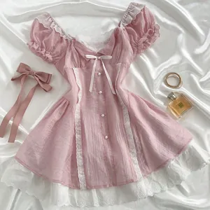 Vintage style pink mini dress with puff sleeves white lace trim and bow accent