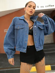 Detail of blue cropped denim jacket with puff sleeves and metal buttons in street style