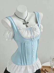 Detailed macro view of slim blue and white patchwork top with bow and button accents