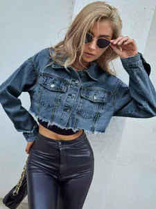 Detailansicht einer modischen, kurzen Jeansjacke mit ausgefranstem Saum und Metallknöpfen