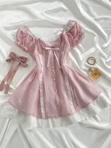 Pink cottagecore mini dress with white lace details, puff sleeves and a dainty bow