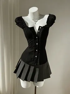 Detailed shot of a black bubble sleeve blouse with pleated ruffles and decorative buttons