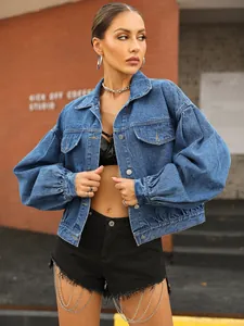 Detailed view of women's short denim jacket with puff sleeves and button pockets