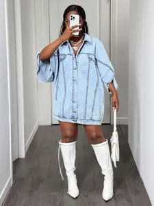 Fashionable oversized denim shirt dress styled with white high boots in a street look