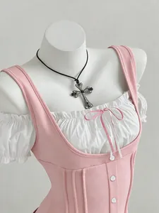 Detailed view of pink patchwork corset top with bow and puff sleeves on mannequin.