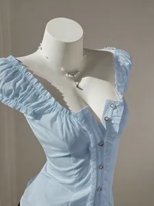 Detail view of light blue puff sleeve blouse with ruffle trim and button front