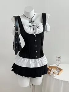 Detailed view of a slim-fit black and white patchwork women's top with bow and ruffles