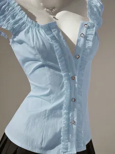 Close-up detail of light blue puff sleeve shirt with romantic ruffles and button-down front.
