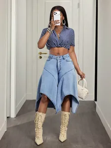 Close-up detail of a stylish asymmetric light blue denim skirt with flared hemline