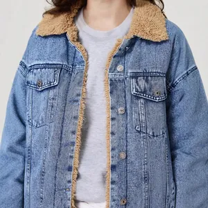 Close-up detail of women's loose blue denim jacket featuring a cozy brown sherpa lining.