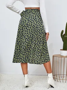 Vista posterior de una falda midi verde de cintura alta con estampado de pétalos