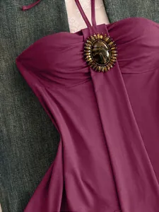 Vue détaillée d'un haut licou bordeaux vintage avec une pierre de marbre décorative.