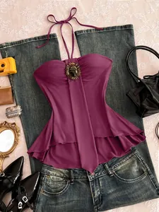 Détail d'un débardeur vintage violet avec broche en pierre et ourlet à volants