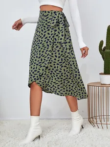 Detalle de una elegante falda cruzada verde estampada con un dobladillo asimétrico