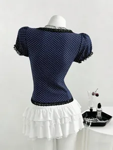 Detailed back view of a navy blue polka dot blouse with delicate black lace edging.