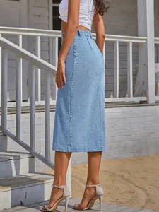 Side view of a high-waisted light blue denim midi skirt worn by a model outdoors.