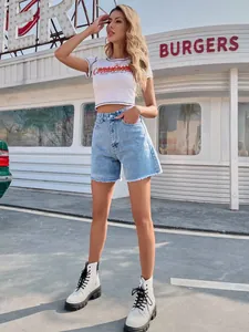 Model street style wearing high-waisted loose blue denim shorts with raw hem details