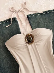 Vue détaillée d'un haut dos nu vintage avec un grand détail de broche en pierre gemme.
