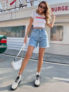 Full body view of a model showcasing the fit of trendy high-waisted loose blue denim shorts