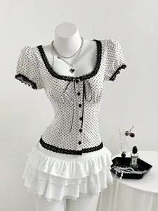 Detail view of a slim fit polka dot blouse with square neck and black lace trim accents.