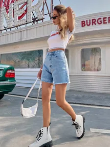 High waist loose denim shorts in light blue wash shown in a retro outdoor street setting