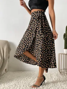 Detalle de falda midi cruzada negra con estampado de corazones y lazada en la cintura