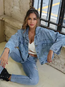 Detail shot showing the texture of a vintage loose-fit light blue denim jacket on a model