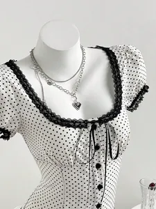 Close-up detail of square neck polka dot blouse with black lace trim and ribbon tie