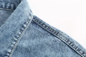 Close-up detail of a retro casual blue denim jacket collar with contrast yellow stitching