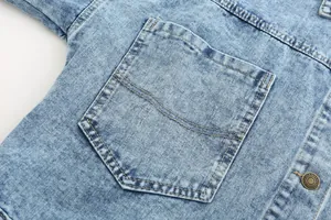 Close-up detail of a vintage washed blue denim jacket featuring a large utility pocket.