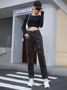 Full length view of women's black high-waisted ripped denim jeans in a street setting