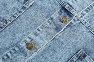 Close-up shot of vintage metal buttons and high-quality washed denim fabric texture