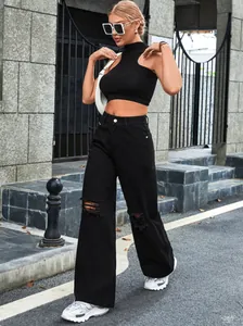 Street style εμφάνιση με μαύρο ψηλόμεσο σκισμένο τζίν παντελόνι και κοντό μαύρο τοπ.