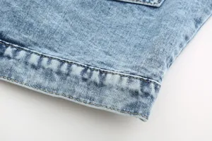 Macro view showing durable double-stitching detail on a retro light blue denim jacket hemline
